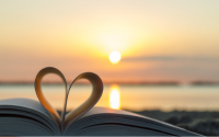 Book pages forming a heart at sunset